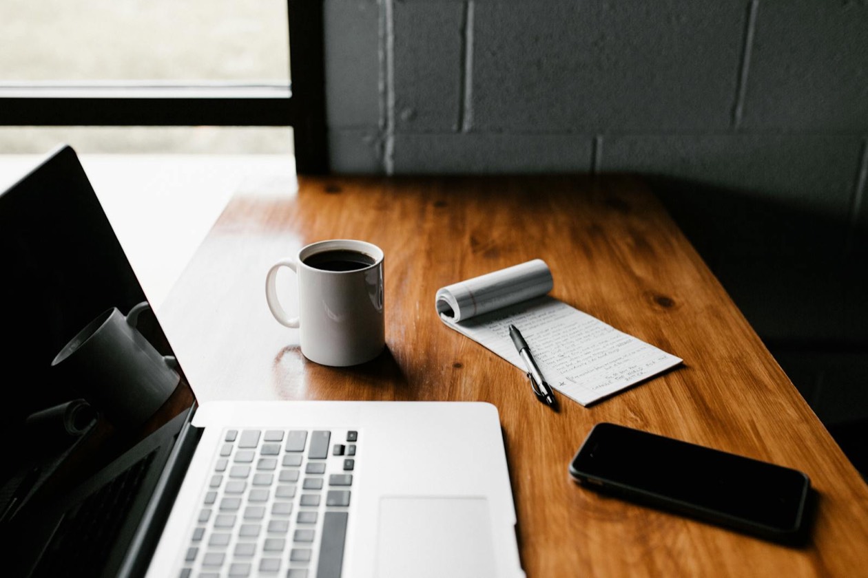 Scrivania con laptop e caffè: tool AI per dati, analytics e no-code accessibili a marketer non tecnici nel 2026