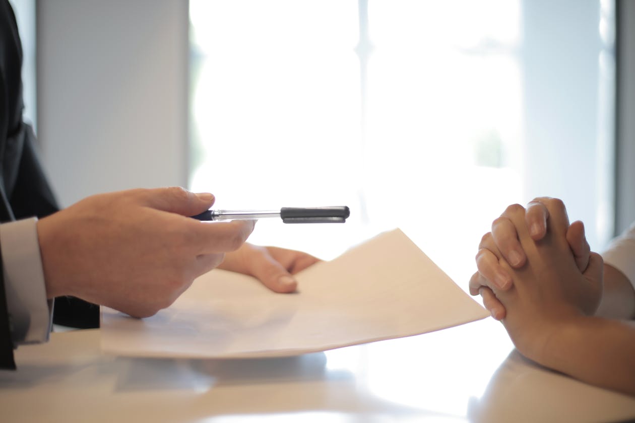 Stretta di mano tra due professionisti su scrivania &mdash; accordo di endorsement marketing tra brand e endorser 2026
