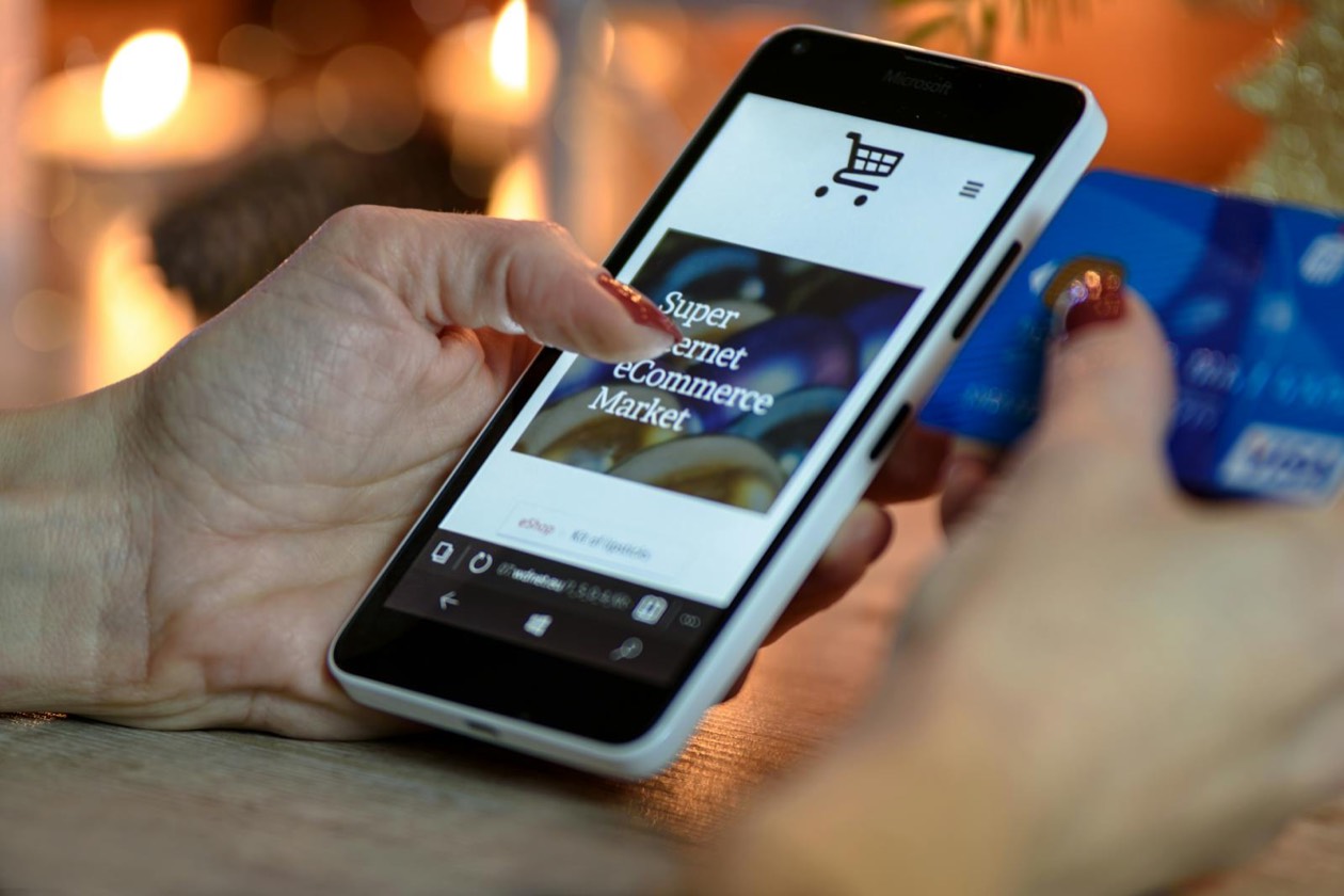 Person using smartphone with payment card &mdash; continuous touchpoints and mental availability for occasional consumers